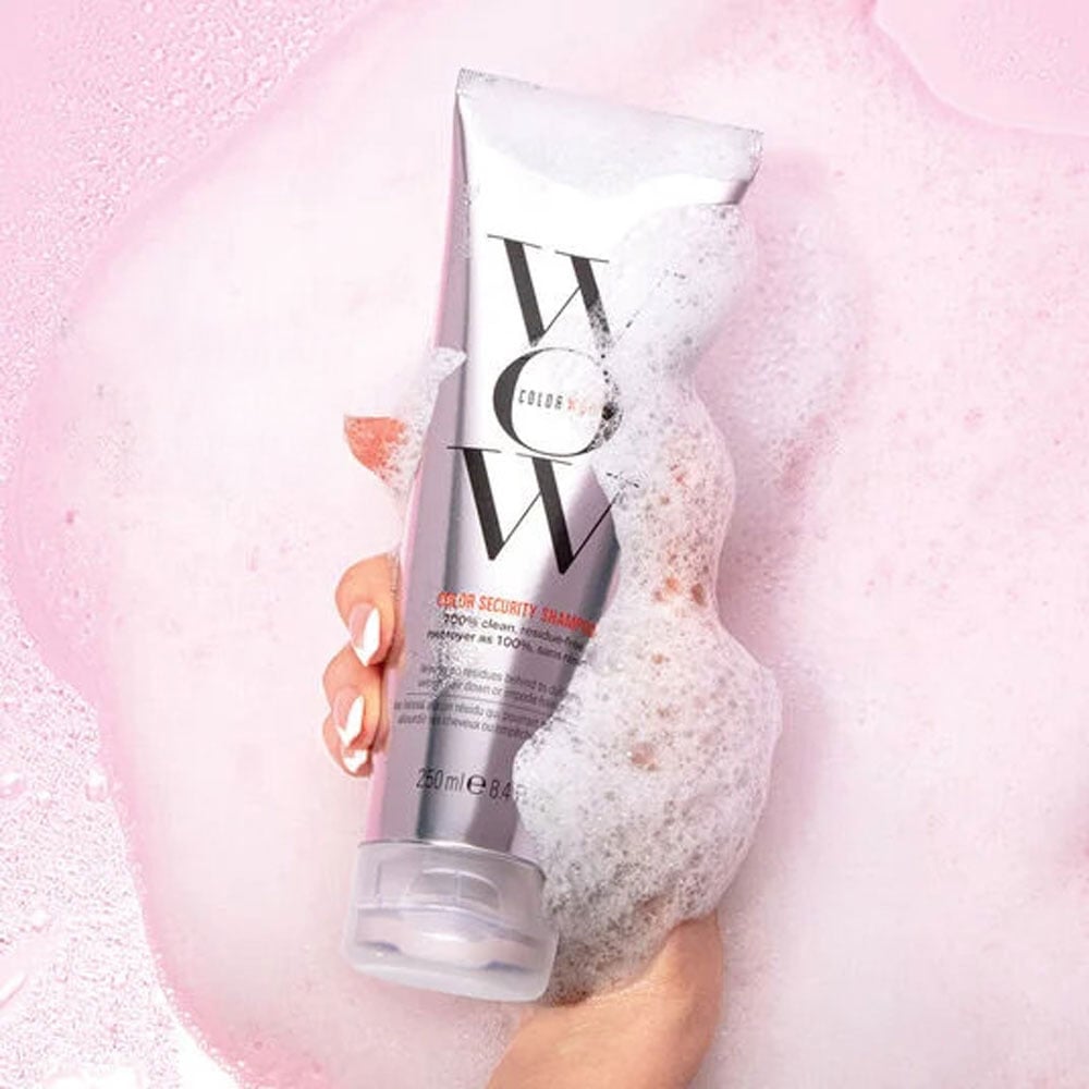 Color Wow shampoo with bubbles on a pink background.